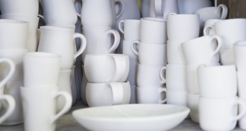 Stacked unfinished white pottery.
