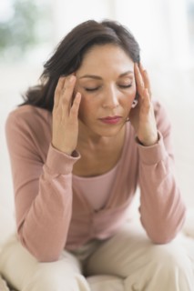 Woman sitting with head in hands.