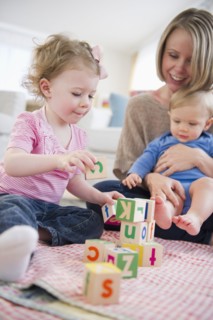 Mother playing with children (2-3, 6-11 months) at home. 
Photo: Jamie Grill