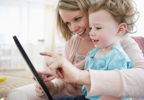 Mother with daughter (-11 months) using digital tablet at home. 
Photo : Jamie Grill