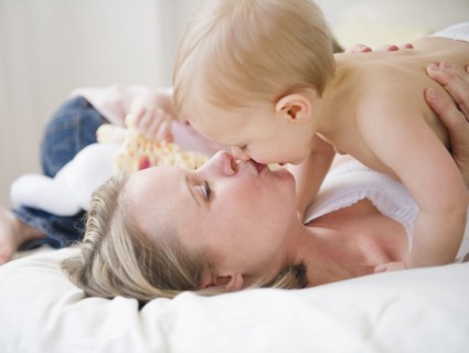 Mother kissing son (6-11 moths), daughter (2-3) in background . 
Photo : Jamie Grill