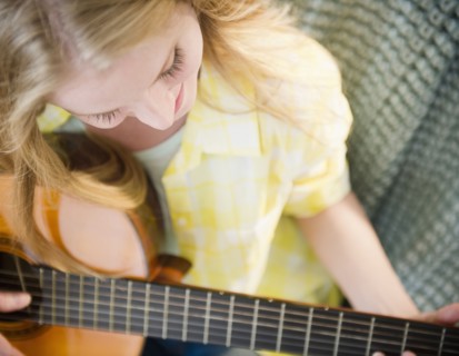 Woman playing guitar. 
Photo : Jamie Grill
