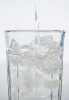 Water being poured into glass with ice cubes. 
Photo: Jamie Grill
