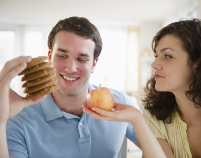 Couple holding cookies and apple. 
Photo: Jamie Grill