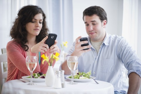 Couple having dinner and text messaging . 
Photo : Jamie Grill