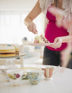 Pregnant woman serving cake. 
Photo : Jamie Grill