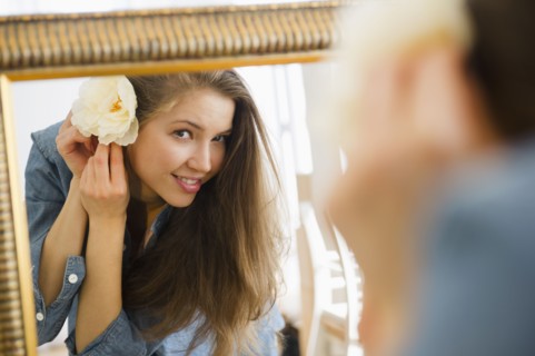Woman adjusting flower in hair. 
Photo : Jamie Grill