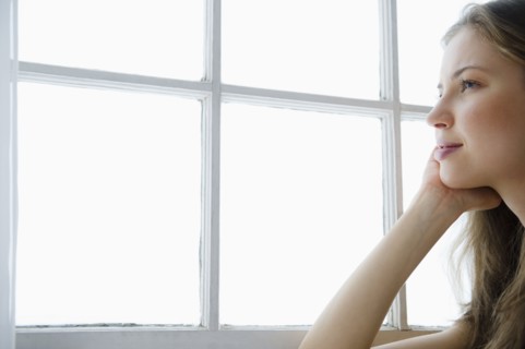 Woman looking through window. 
Photo : Jamie Grill