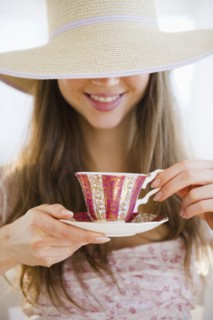 Woman wearing sun hat drinking tea. 
Photo : Jamie Grill