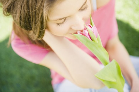 Woman smelling flower. 
Photo : Jamie Grill