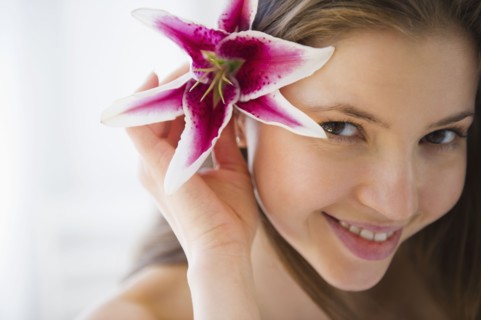 Portrait of woman with tropical flower in hair. 
Photo : Jamie Grill
