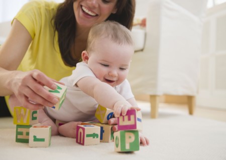 Mother and baby daughter (6-11 months) playing with blocks. 
Photo : Jamie Grill