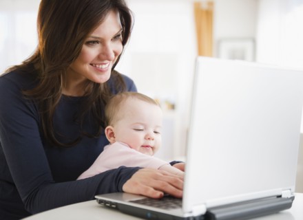 Mother with baby daughter (6-11 months) using laptop. 
Photo : Jamie Grill