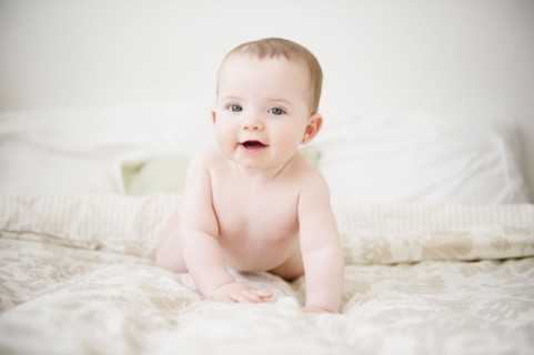 Baby girl (6-11 months) lying on bed. 
Photo : Jamie Grill