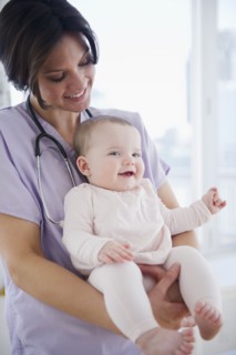 Female nurse with baby girl (6-11 months). 
Photo : Jamie Grill