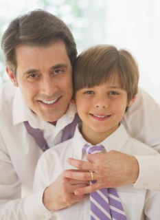 Father helping son (10-11 years) to tie tie. 
Photo : Daniel Grill