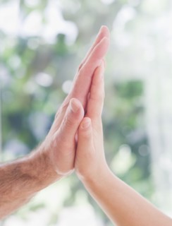 Close up of father's and son's (10-11 years) hands doing high five. 
Photo : Daniel Grill