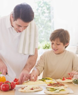 Father and son (10-11 years) preparing pizza. 
Photo : Daniel Grill