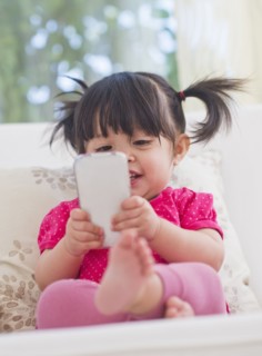 Baby girl (12-17 months) playing with mobile phone. 
Photo : Daniel Grill
