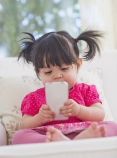 Baby girl (12-17 months) playing with mobile phone. 
Photo : Daniel Grill