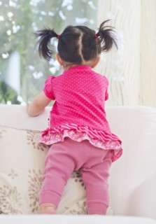 Baby girl (12-17 months) looking through window. 
Photo : Daniel Grill