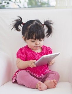 Baby girl (12-17 months) playing with digital tablet. 
Photo : Daniel Grill