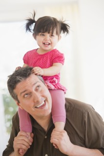 Father carrying baby daughter (12-17 months) on shoulders. 
Photo : Daniel Grill