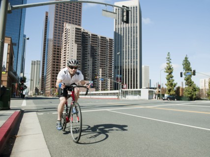 USA, California, Los Angeles, Young man road cycling on city street.