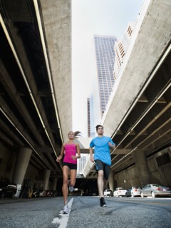 USA, California, Los Angeles, Young man and young woman running on city street. 
Photo: Erik
