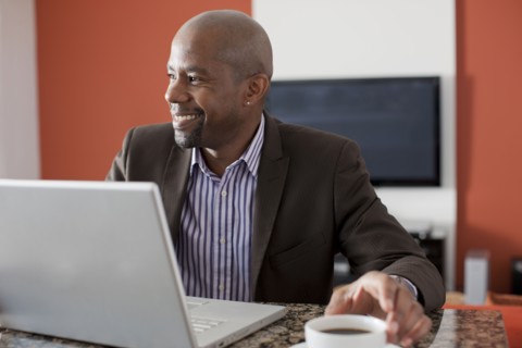 Man enjoying coffee while using laptop. 
Photo : Dan Bannister