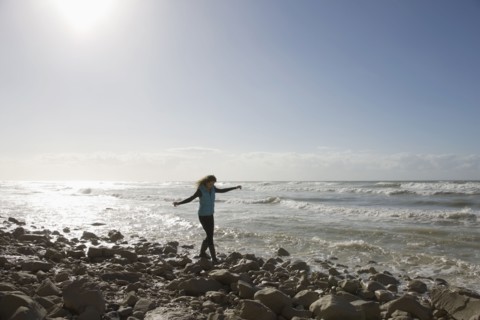 France, Pas-de-Calais, Escalles, Young woman strolling on rocky beach. 
Photo : Jan Scherders