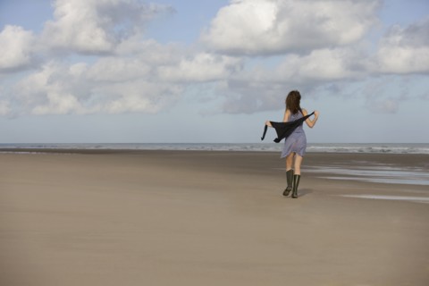 France, Pas-de-Calais, Escalles, Young woman strolling on empty beach. 
Photo : Jan Scherders