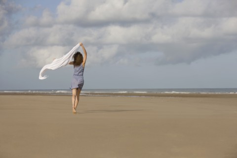 France, Pas-de-Calais, Escalles, Young woman strolling on empty beach. 
Photo : Jan Scherders