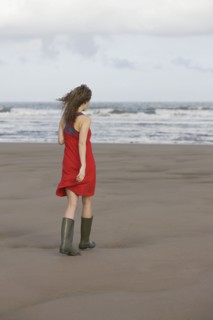 France, Pas-de-Calais, Escalles, Young woman strolling on empty beach. 
Photo : Jan Scherders