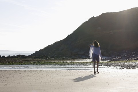 France, Pas-de-Calais, Escalles, Young woman strolling on empty beach. 
Photo : Jan Scherders