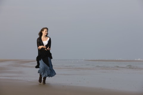 France, Pas-de-Calais, Escalles, Young woman strolling on empty beach. 
Photo: Jan Scherders