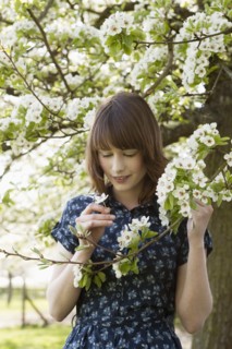Portrait of young woman in blooming orchard. 
Photo : Jan Scherders