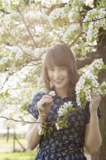 Portrait of young woman in blooming orchard. 
Photo : Jan Scherders
