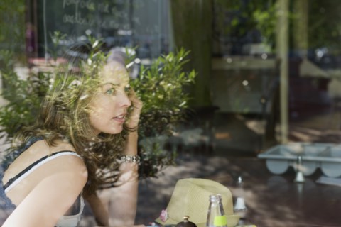 Holland, Amsterdam, Woman in cafe talking mobile phone. 
Photo : Jan Scherders
