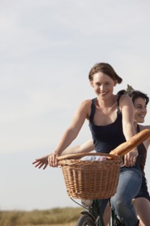 Young women on bikes on country road. 
Photo : Jan Scherders