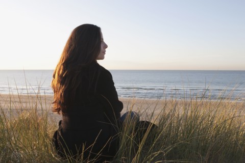 Netherlands, Zeeland, Haamstede, Woman relaxing on sand dune. 
Photo: Jan Scherders