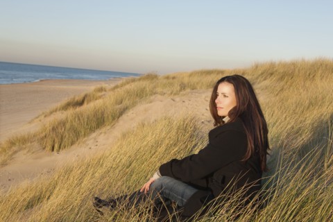 Netherlands, Zeeland, Haamstede, Woman relaxing on sand dune. 
Photo: Jan Scherders