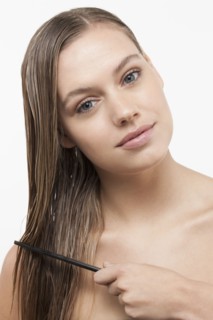Portrait of young woman with wet hair and comb. 
Photo : Jan Scherders