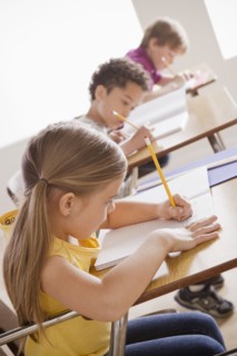 Schoolchildren focused on writing in classroom. 
Photo : Rob Lewine