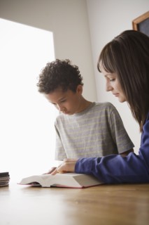 Schoolboy reading with teacher in classroom. 
Photo: Rob Lewine
