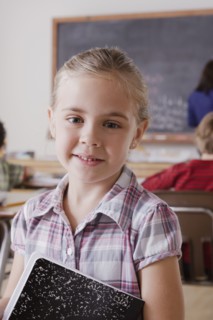 Portrait of schoolgirl holding notebook. 
Photo : Rob Lewine