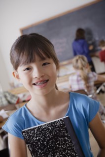 Portrait of schoolgirl holding notebook. 
Photo : Rob Lewine