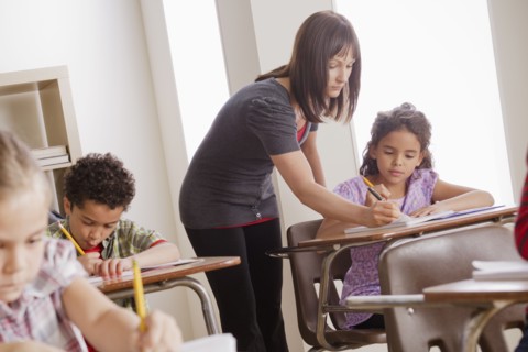 Teacher helping schoolchildren (6-7,8-9). 
Photo : Rob Lewine
