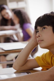 Portrait of schoolboy (12-13) contemplating. 
Photo : Rob Lewine