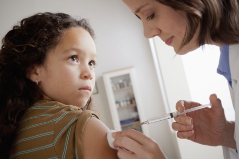 Girl (8-9) having vaccination. 
Photo : Rob Lewine
